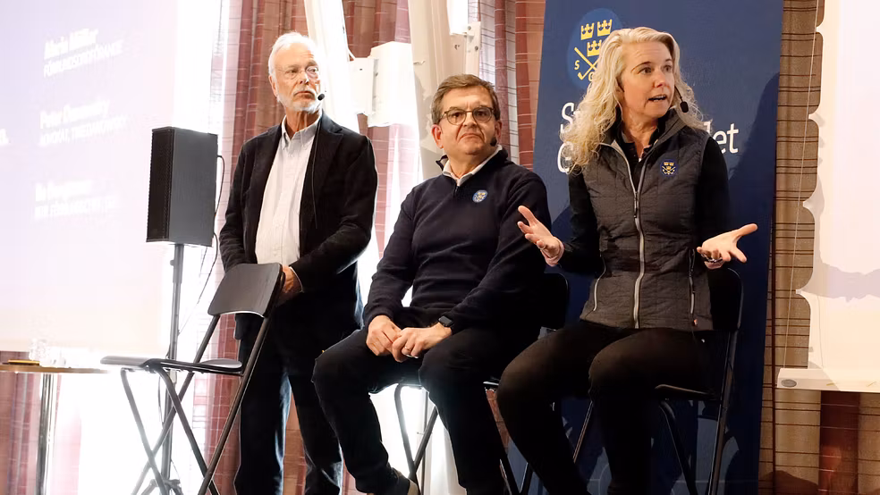 Tre personer i en paneldiskussion på en scen.
