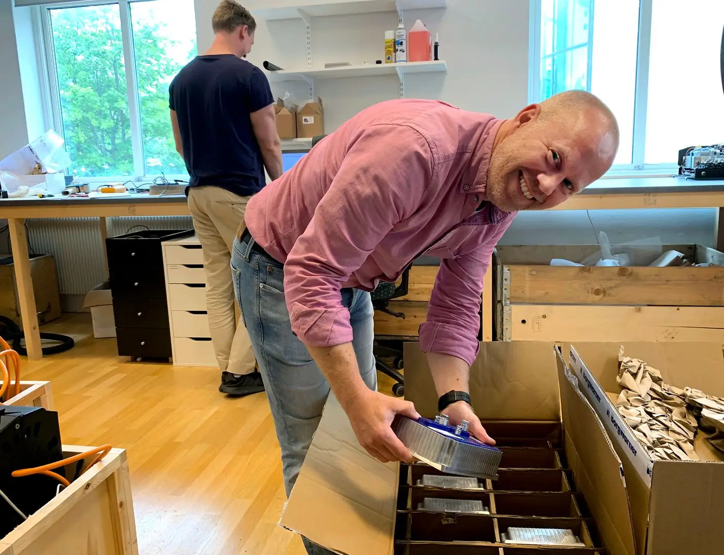 Oscar Theen packar upp en leverans i verkstan.