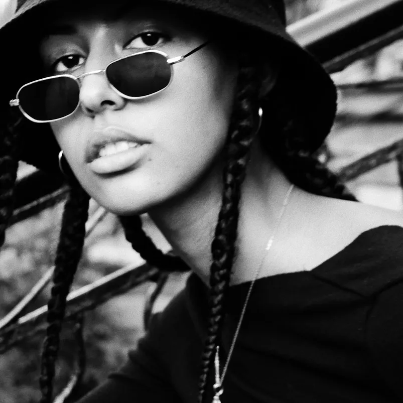 Black and white photo of a young girl sitting on a staircase.
