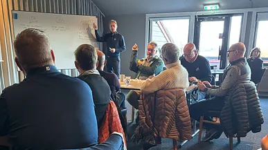 Grupp av golfklubbledare och funktionärer samlade i ett klassrum under en utbildningssession.