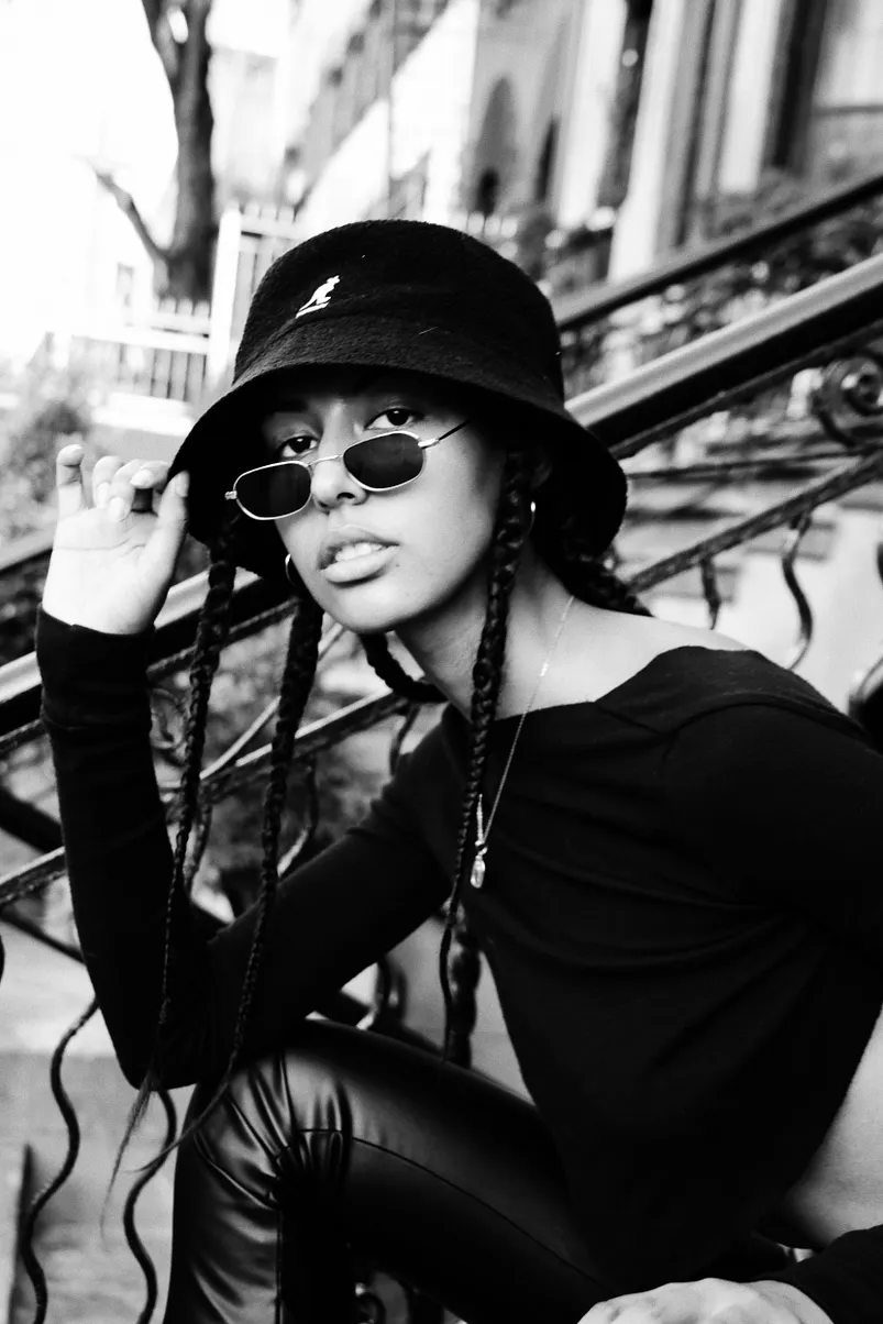 Black and white photo of a young girl sitting on a staircase.