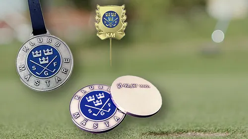 Golfmärken och golfboll på gräsmatta