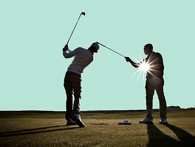 Golftränare hjäper en elev med sin sving